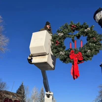 Bucket truck beside a large holiday wreath